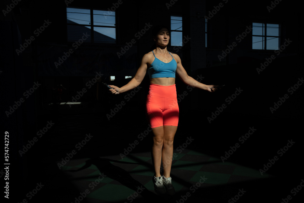Athletic woman performs jumping rope in crossfit gym. Athletic woman performs jumping rope in crossfit gym.