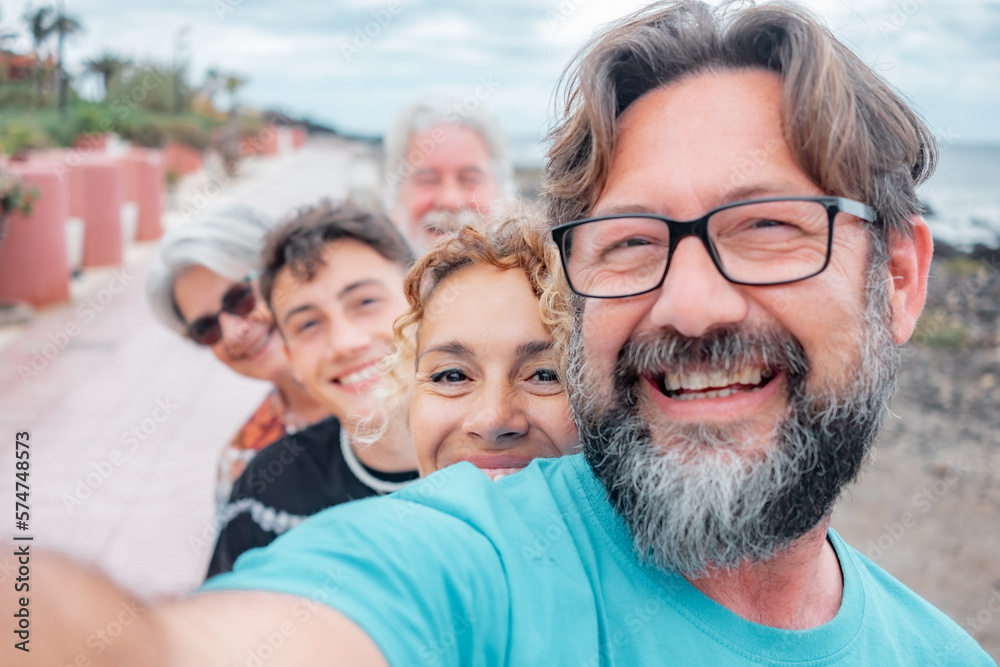 Happy group of multi generation family having fun together in outdoor, five people smiling joyful looking at camera expressing love and happiness Happy group of multi generation family having fun together in outdoor, five people smiling joyful looking at camera expressing love and happiness