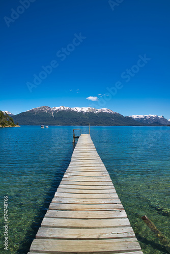 Long pier towards the lake of Villa La Angostura in Patagonia. Mountains in the background