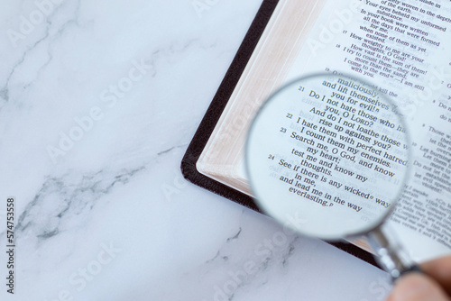 Magnifying glass over open holy buble book of psalms 139 verses. Top table view. Copy space. Searching, examining, and studying Old Testament Scriptures, Christian biblical concept.