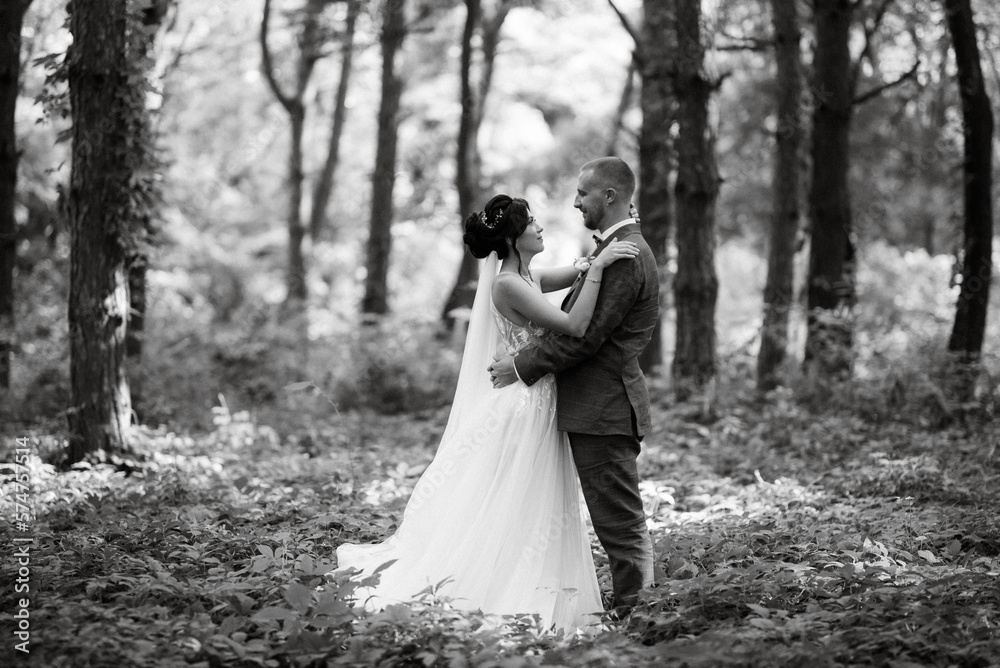 wedding walk of the bride and groom in the deciduous forest in summer wedding walk of the bride and groom in the deciduous forest in summer