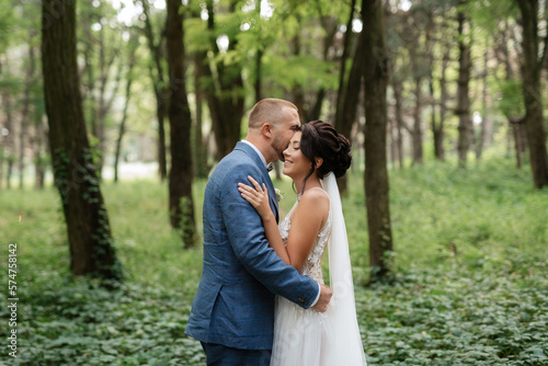wedding walk of the bride and groom in the deciduous forest in summer © omelnickiy