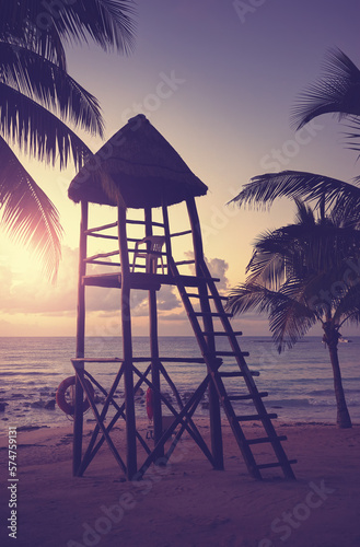 Fototapeta Naklejka Na Ścianę i Meble -  Lifeguard tower on a Caribbean beach at sunset, color toning applied.