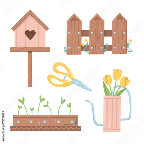 Decorative set of a wooden birdhouse, a fence, a watering can, pot with seedlings and garden shears photo