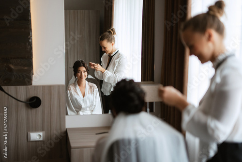 make-up artist makes a wedding look to the bride with makeup