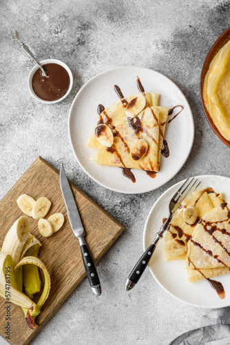 Delicious fresh baked pancakes with honey and fruits on a concrete background