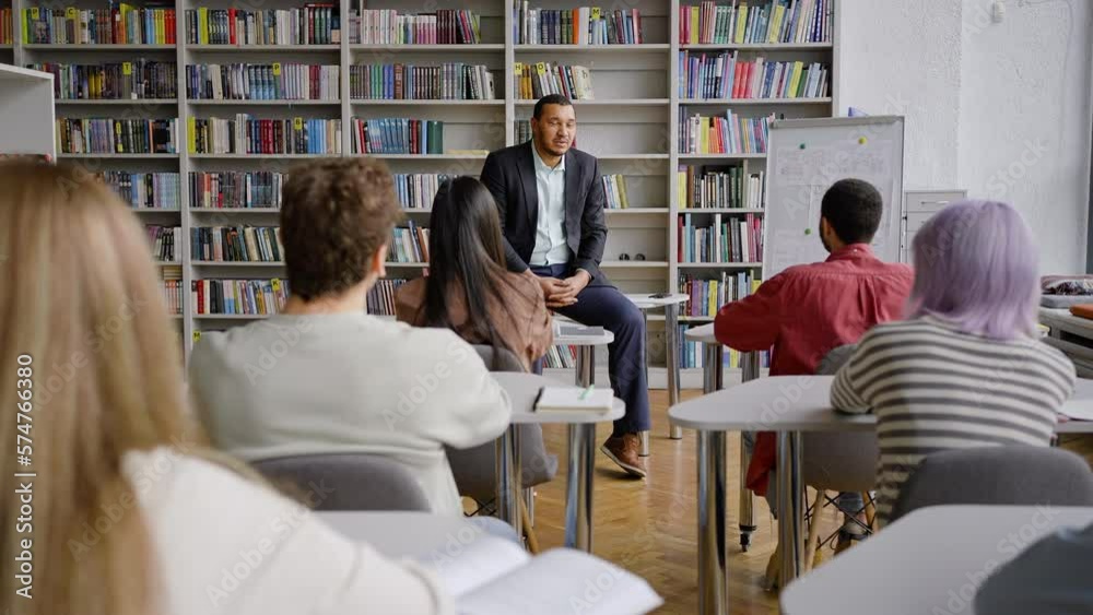Young African American professor teaching a lecture at library campus of a high school establishment Young African American professor teaching a lecture at library campus of a high school establishment