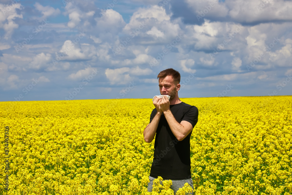 man in field blowing his nose and suffering from hay fever. man in field blowing his nose and suffering from hay fever.