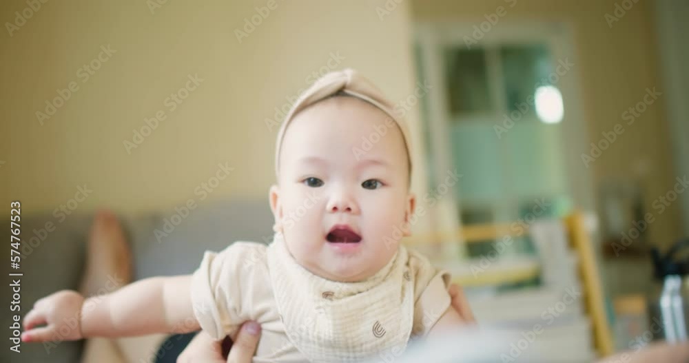 Happy Mother and baby playing bonding activity together in living room. little cute Asian baby infant child girl excited laughing and fun spend quality time on sofa Family having fun at home Happy Mother and baby playing bonding activity together in living room. little cute Asian baby infant child girl excited laughing and fun spend quality time on sofa Family having fun at home