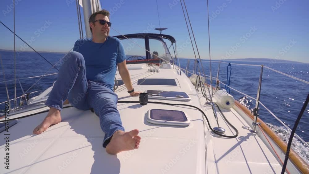 Man relaxing on sailing yacht boat ocean sunny day, travel adventure lifestyle Man relaxing on sailing yacht boat ocean sunny day, travel adventure lifestyle
