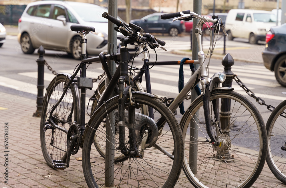 Bicycles stand next to each other, in the background are roads and cars.