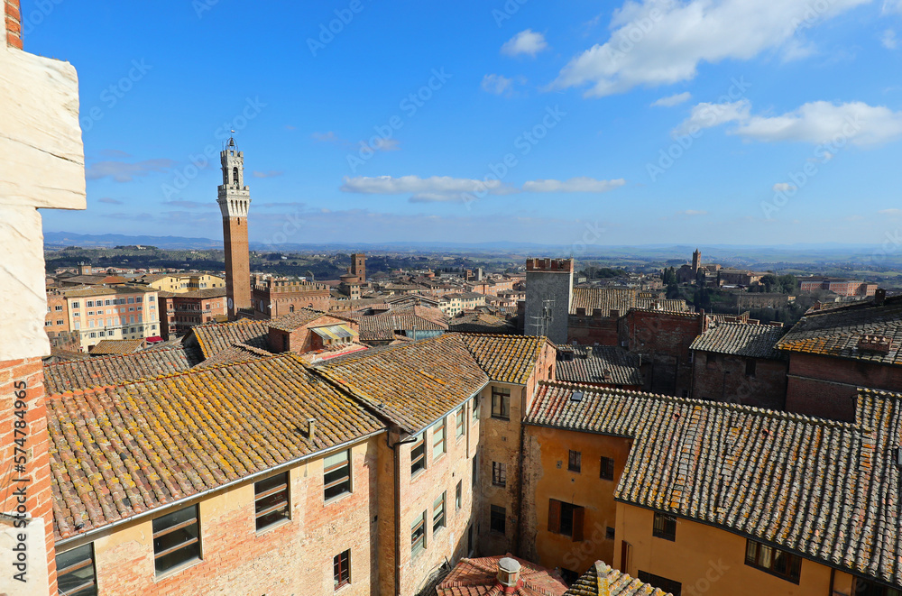 tower of the city of Siena called DEL MANGIA seen from above of the roofs of the Italian city