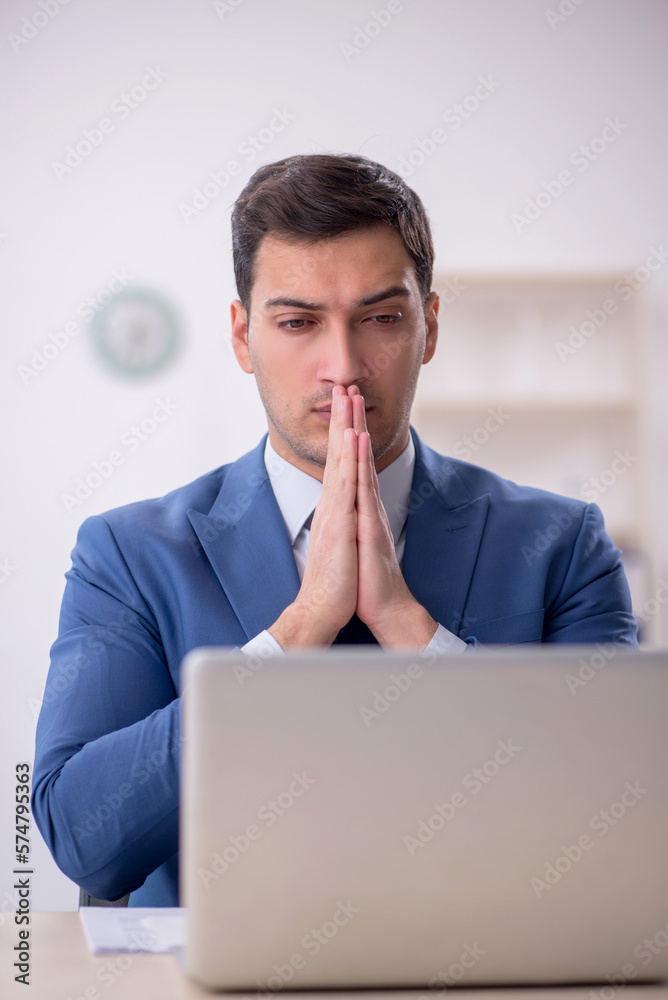 Young male employee working in the office Young male employee working in the office