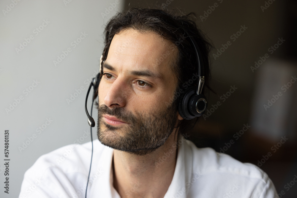 portrait d'un jeune télé conseiller. Il porte un micro casque et répond aux appels téléphoniques. Il est beau et souriant. portrait d'un jeune télé conseiller. Il porte un micro casque et répond aux appels téléphoniques. Il est beau et souriant.