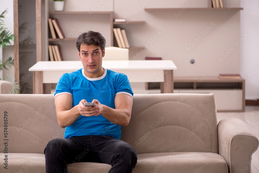 Fototapeta premium Young man watching tv at home