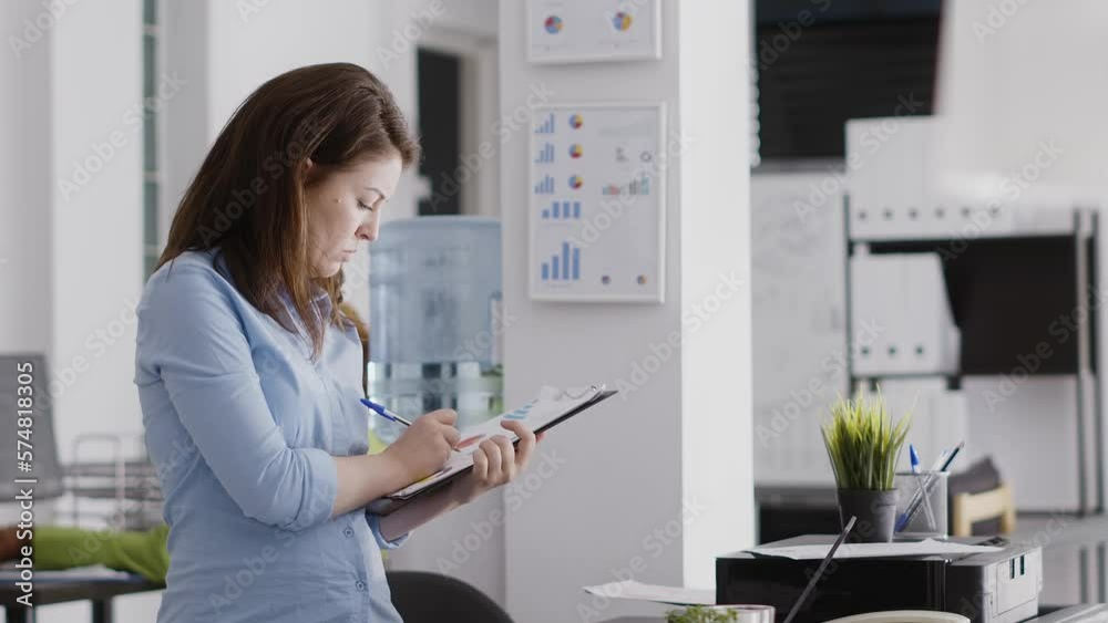 Business manager writing data analytics on papers, working with professional corporate report to increase profit. Young woman taking notes on files for investment plan development. Business manager writing data analytics on papers, working with professional corporate report to increase profit. Young woman taking notes on files for investment plan development.