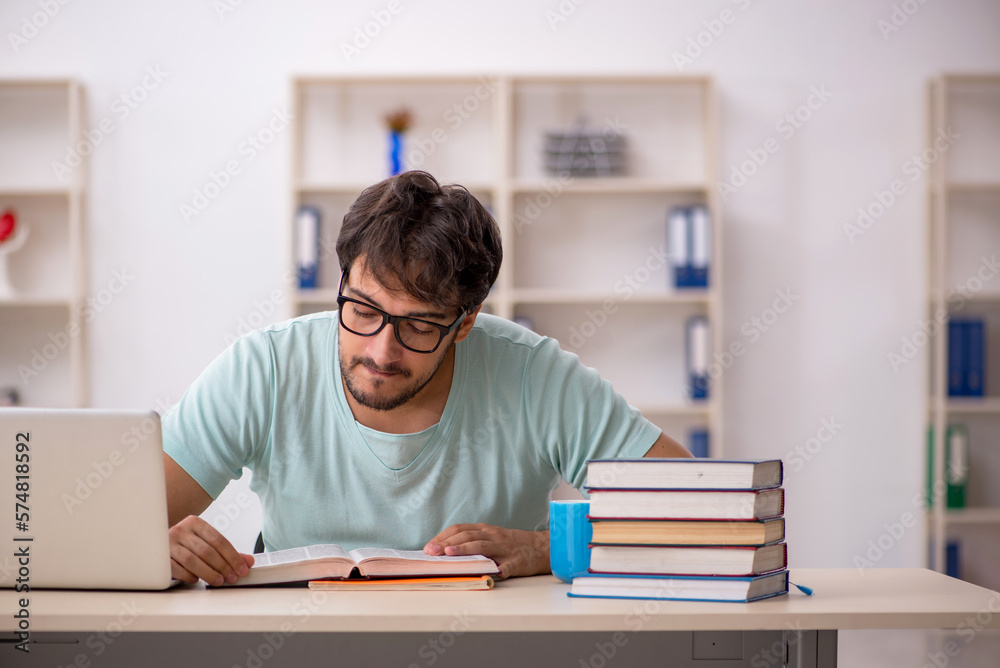 Young male student preparing for exams in the classroom Young male student preparing for exams in the classroom