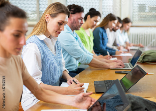 Small group of students attentively listening to lecture in university classroom