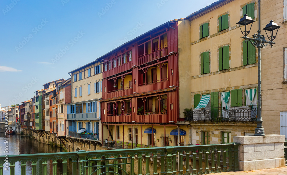 View from bridge of Castres townscape overlooking old colorful houses along Agout river on sunny summer day, Tarn department France