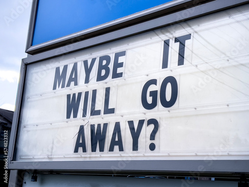 Close up view of the words Maybe It Will Go Away on a letter board sign outdoors