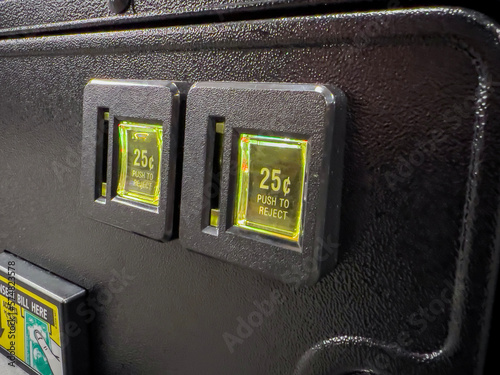 Selective focus on the coin slot on an arcade machine inside a video game store