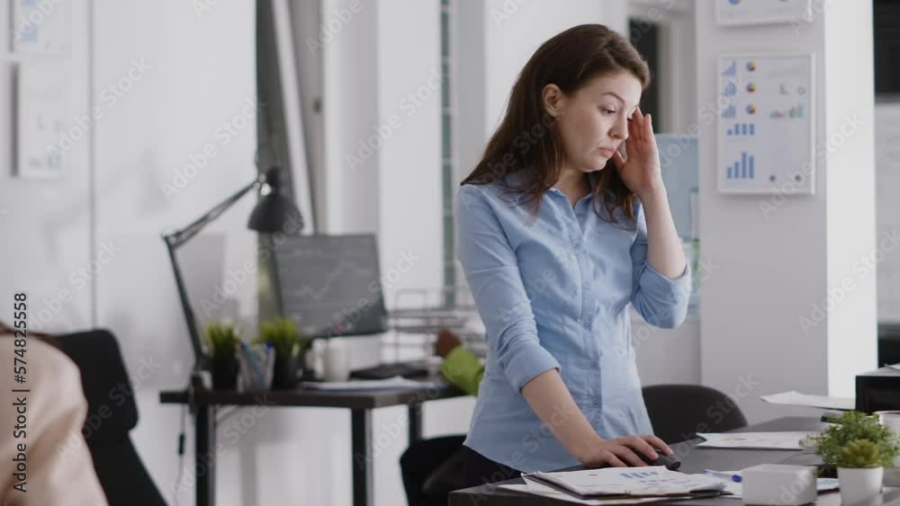 Young employee dealing with headache and working on computer, rubbing temples and feeling worried about pain. Female entrepreneur having painful migraine at desk, work under pressure. Young employee dealing with headache and working on computer, rubbing temples and feeling worried about pain. Female entrepreneur having painful migraine at desk, work under pressure.