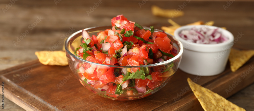 Bowl of tasty Pico de Gallo salsa on table, closeup Bowl of tasty Pico de Gallo salsa on table, closeup