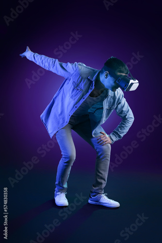Young man using VR glasses on dark color background