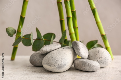 Spa stones, eucalyptus and bamboo on light background