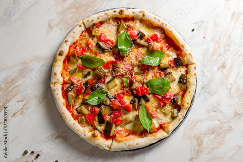 pizza with eggplant, tomatoes and cheese on white marble table top view photo