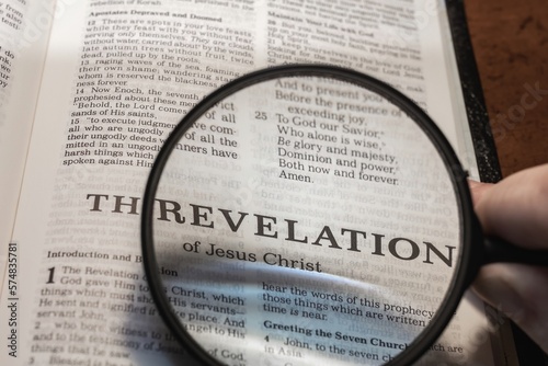 Fototapet title page book of Revelation close up using magnifying glass in the bible for f