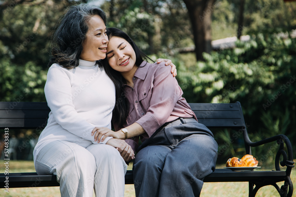 Fototapeta premium Asian young caregiver nurse support senior older male walking outdoors. Specialist girl doctor help and take care of elderly mature man patient doing physical therapy in public park at nursing home.