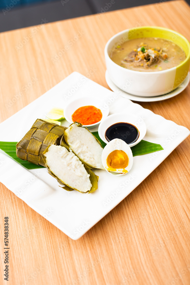 A Traditional Makassar dish, called Coto Makassar served with packed rice and a side of salted egg A Traditional Makassar dish, called Coto Makassar served with packed rice and a side of salted egg