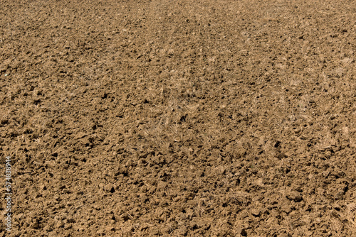 Close up of soil surface or fertilizer being handled for rice field farming.