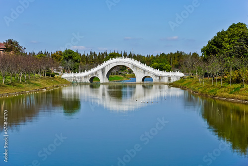 White arched bridge over peaceful lake Shanghai bay national forest park China