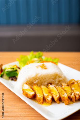 A Lemon Chicken Cutlet Dish, Servied with Rice and a side of salad photo