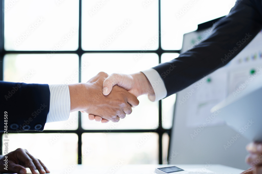 Asian entrepreneurs handshakes to congratulate the agreement between the two companies to enhance investment and financial strength. deal concept