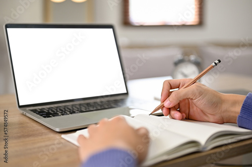 Close-up image of a male student doing homework. laptop white screen mockup