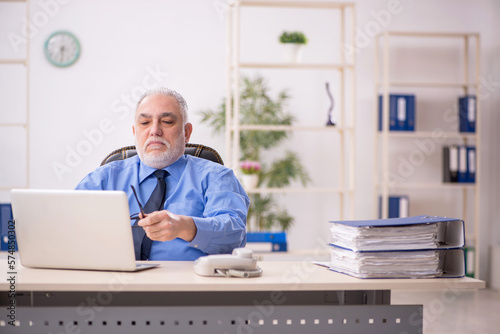 Old male employee working in the office