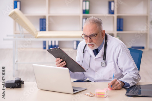 Old male doctor working in the clinic