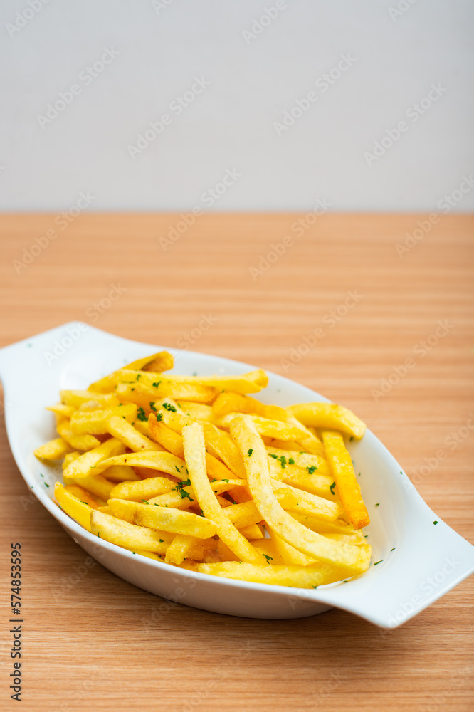 A Plate of french fries served with parsley leaf A Plate of french fries served with parsley leaf