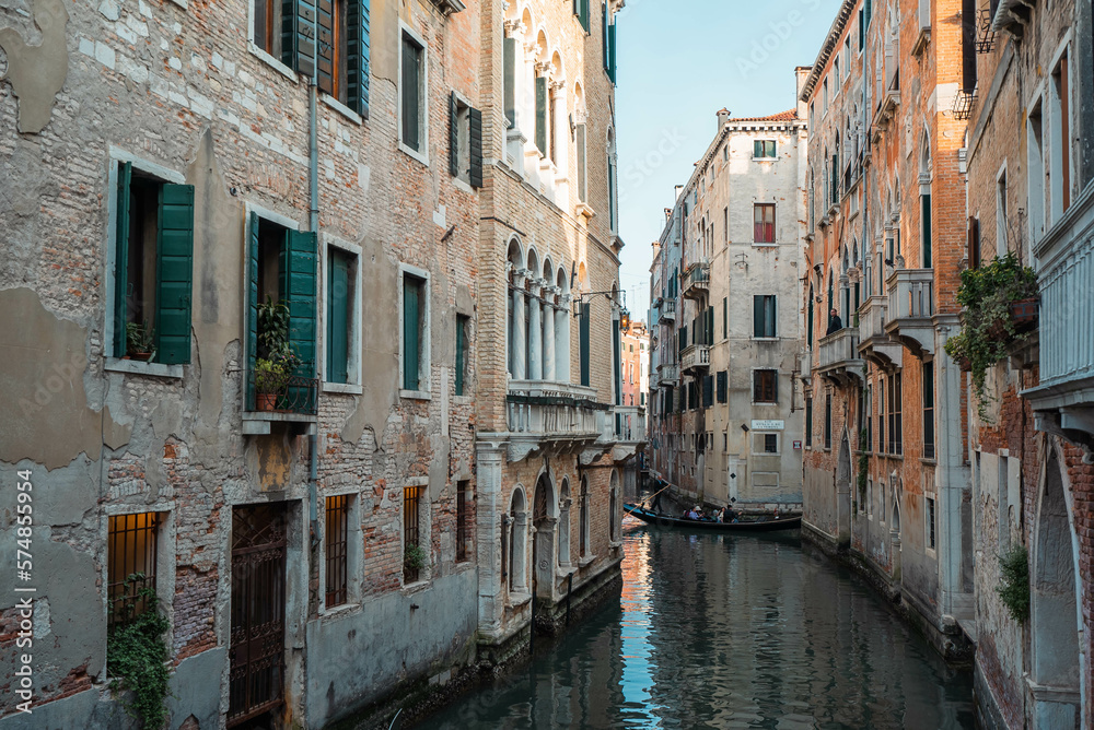 Venice Canal is lined on either side by Romanesque, Gothic, and Renaissance buildings in Venice, Italy.