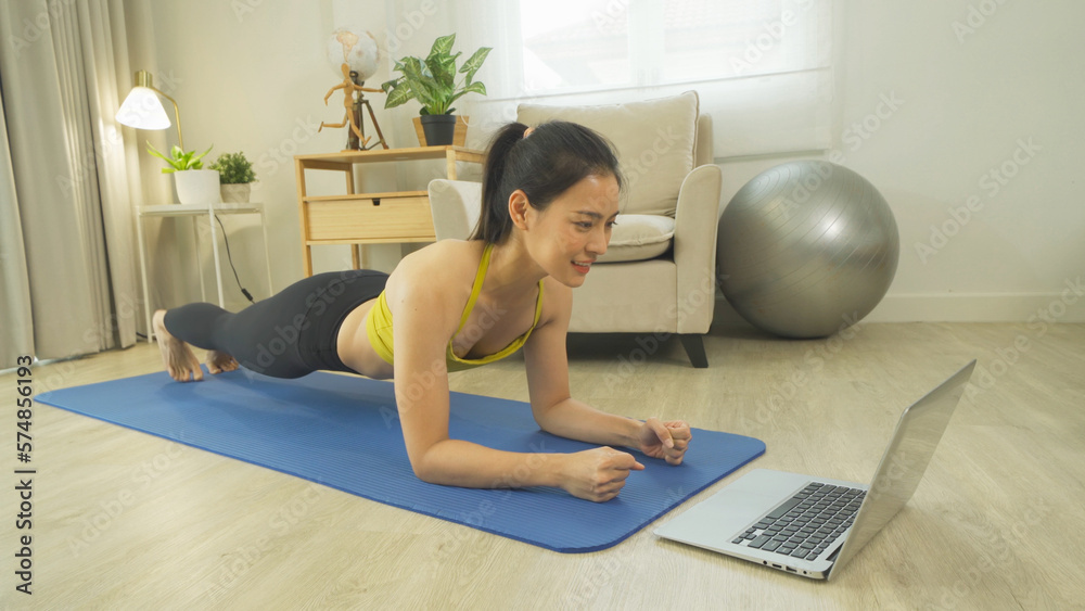 Portrait of Asian woman in yoga class club doing exercise, at home or house. Indoor online sport and recreation. People lifestyle activity. Self-isolate. Quarantine in room Portrait of Asian woman in yoga class club doing exercise, at home or house. Indoor online sport and recreation. People lifestyle activity. Self-isolate. Quarantine in room