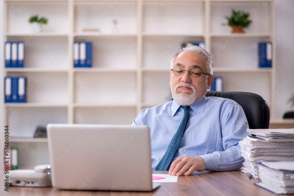 Old male employee working in the office
