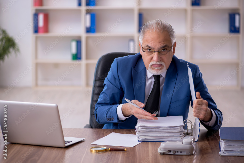 Old male employee working in the office Old male employee working in the office