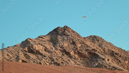 4K: Paragliders have free flying over UAE mountains, an adventure sports concept photo