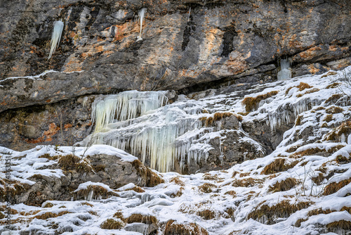 Rocky hillside with frozen icicles above the Gosausee, Austria 
