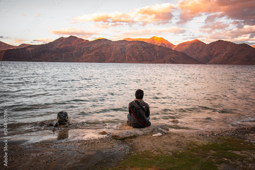 The man sitting in front of Pangong lake in evening, Leh Ladakh, India