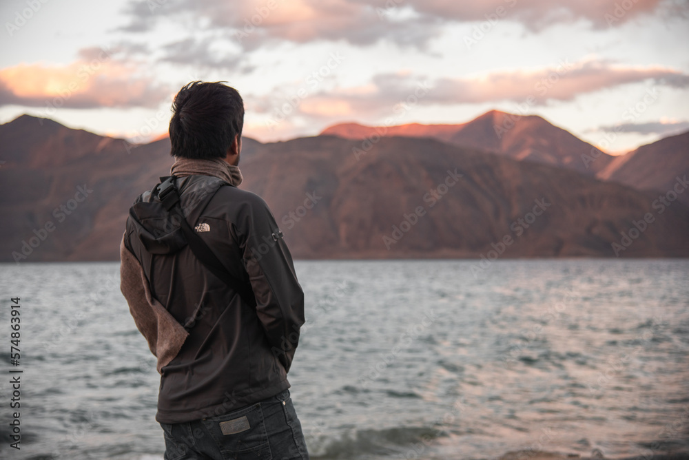 A lonely man standing in front ofPangong lake in evening, Leh Ladakh, India
