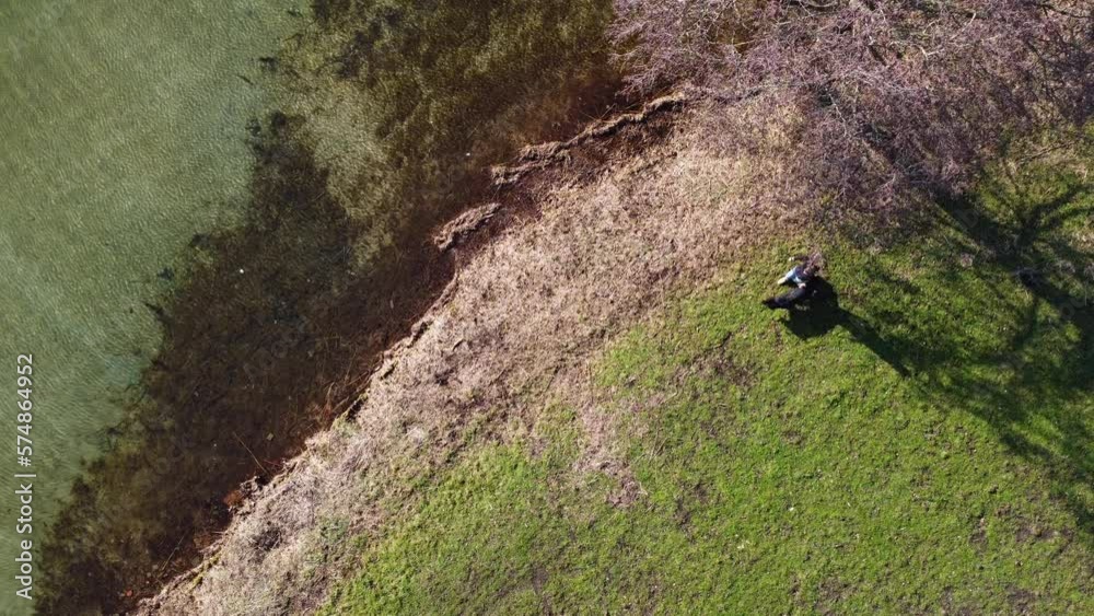 Shot from above from man walking his dog in a park. Shot from above from man walking his dog in a park.